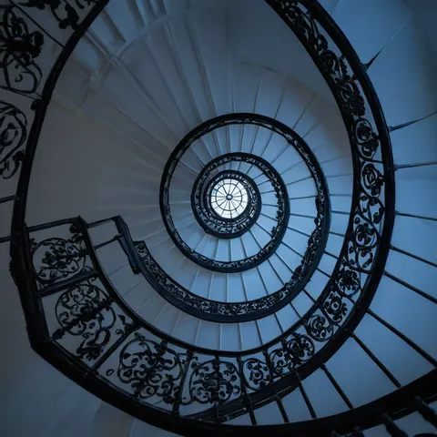 Spiral staircase with black iron railings and white steps leading up to a skylight