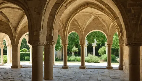Stone cloister with arched walkways overlooking a green garden